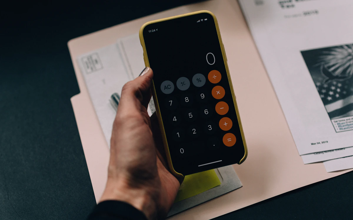 Clean desk with a calculator, pen, notepad with calculations, and financial planning notes